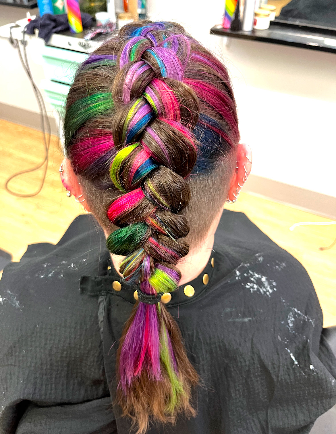 brown hair braided with rainbow highlights mixed in